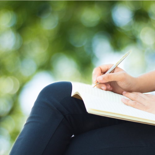 膝の上で何かをメモする人