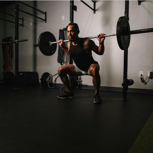 バーベルスクワットする男性