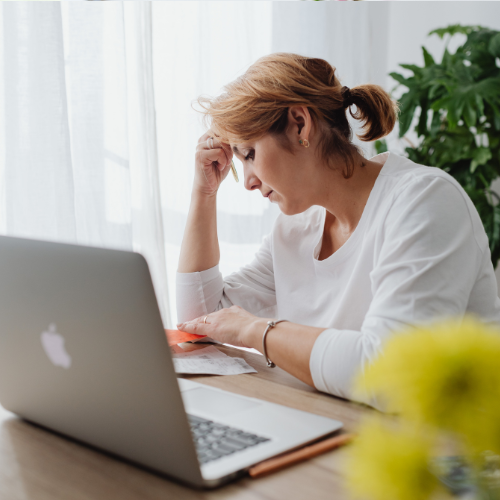 パソコンの前で悩む女性